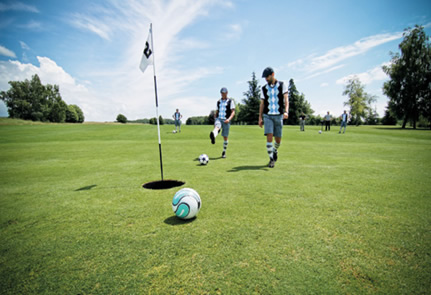 Kicking soccer ball on golf course