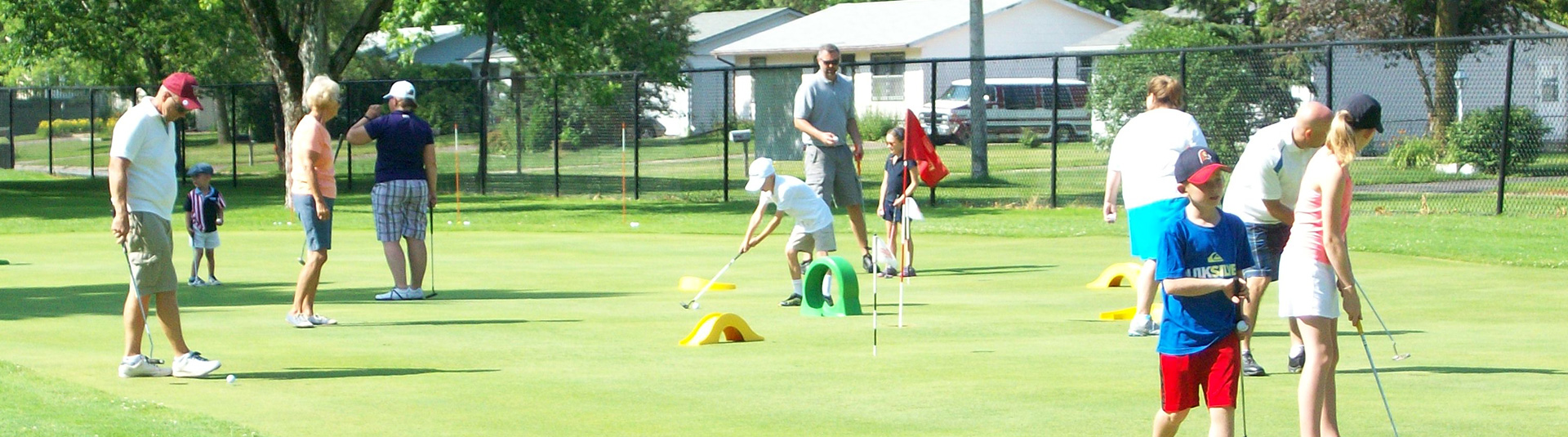 Kids and adults playing golf